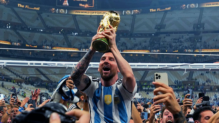 Lionel Messi mengangkat trofi Piala Dunia
